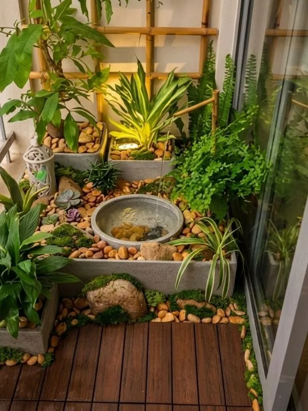 Petit balcon japonais décoré avec structures en bois rouge, pots de plantes vertes et galets blancs, créant une ambiance zen et harmonieuse