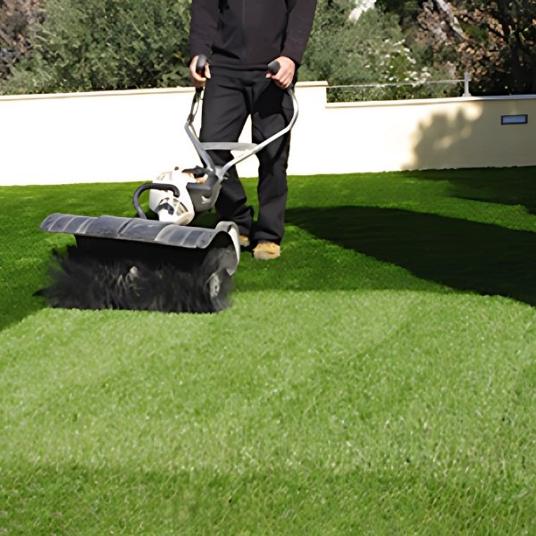 Brosse électrique professionnelle redressant les fibres d’un gazon synthétique pour un entretien en profondeur