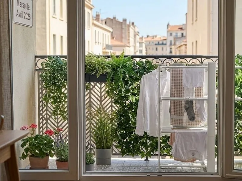 Brise-vue Balconnova et plantes cachant un étendoir à linge.