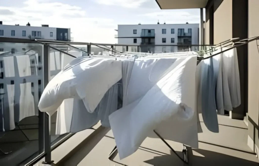 Séchage de draps blancs sur balcon au soleil.