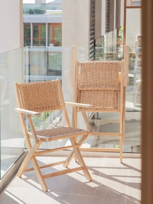 Fauteuil pliant en rotin suspendu ou replié contre le mur d'un balcon étroit