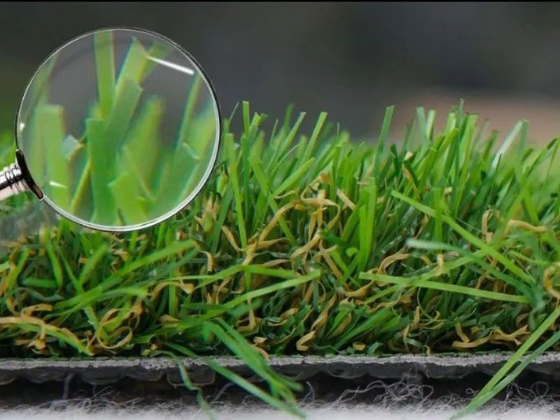 Zoom sur les brins denses d'un gazon artificiel haut de gamme pour balcon urbain